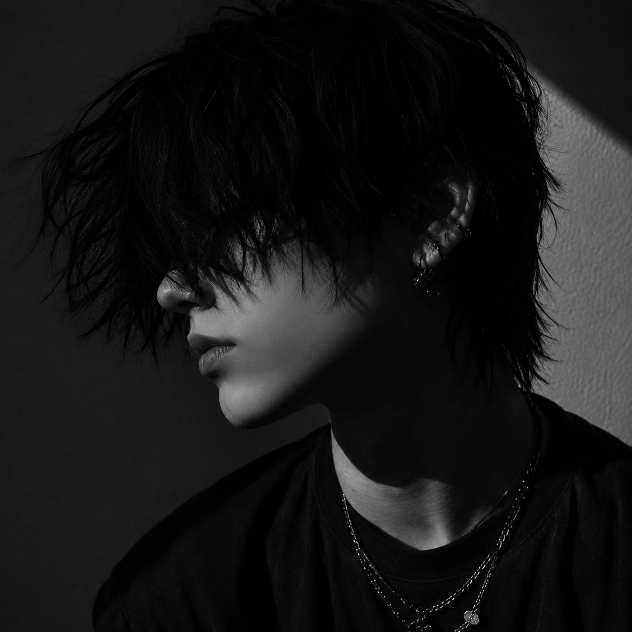 Monochrome emo aesthetic PFP showing a side profile with sharp shadows and dark hair
