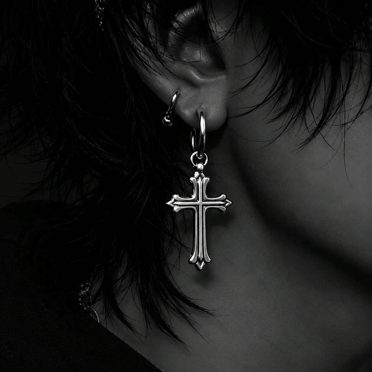 Monochrome emo Discord PFP focused on one ear wearing a chunky silver cross earring