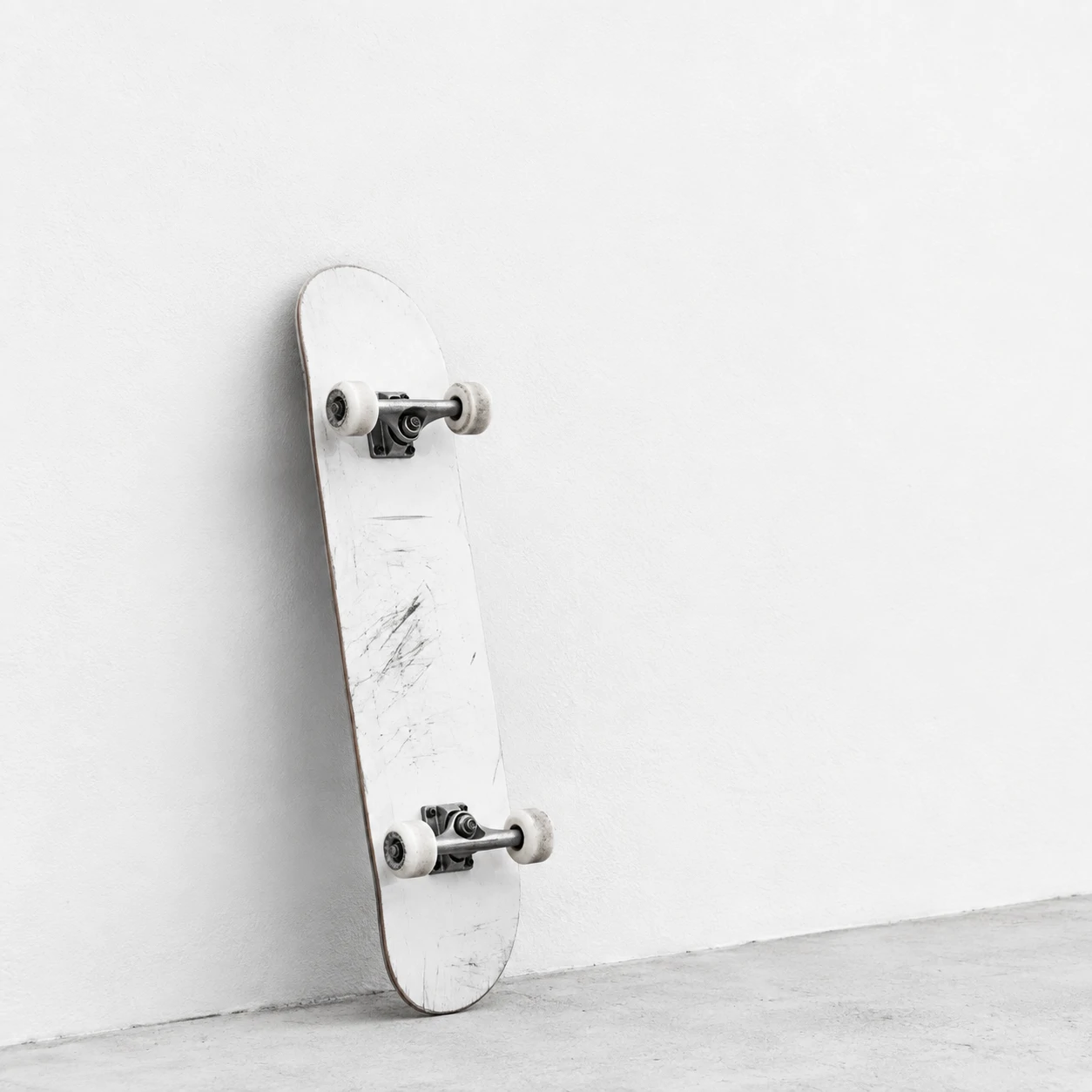 Minimal white PFP for boys with a skateboard against a plain white wall